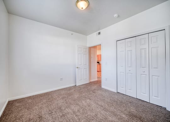 a bedroom with white walls and carpet