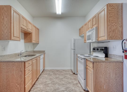 a kitchen with wood cabinets and white appliances