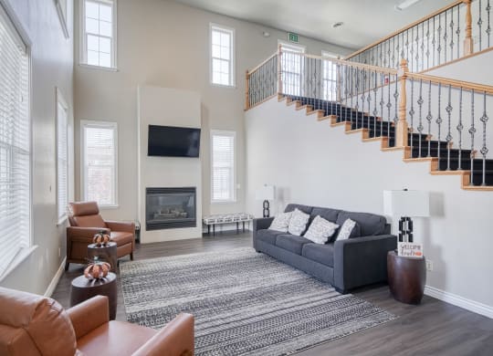 a living room with a staircase in the background and a couch and chair in the foreground