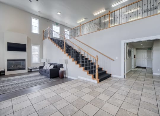 a spacious living room with a staircase leading up to the second floor