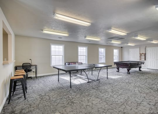 a games room with two ping pong tables and a foosball table