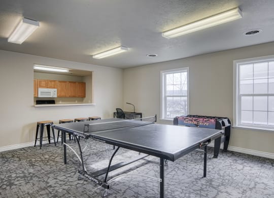 a room with a ping pong table and a couch