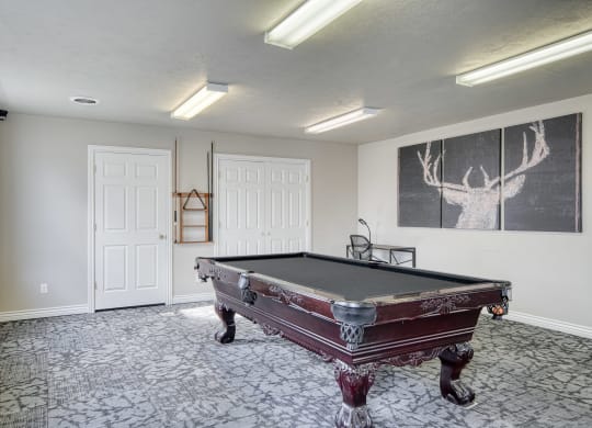a game room with a pool table and a chalkboard on the wall