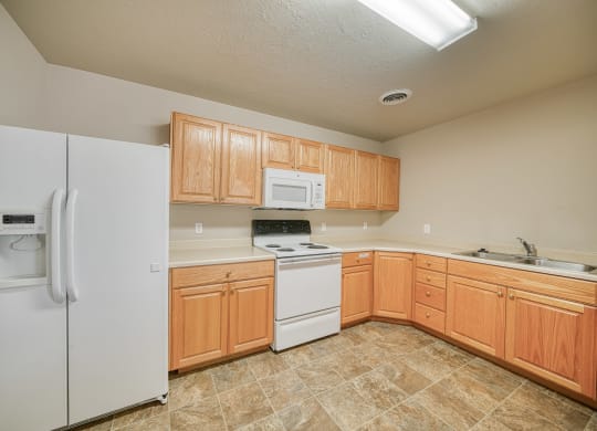a kitchen with white appliances and wooden cabinets