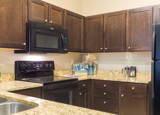 a kitchen with black appliances and granite counter tops at Sugar House Apartments By Urbana, Salt Lake City, UT, 84105