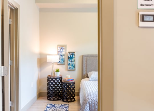 a bedroom with a bed and a nightstand with a lamp at Sugar House Apartments By Urbana, Salt Lake City, UT, 84105