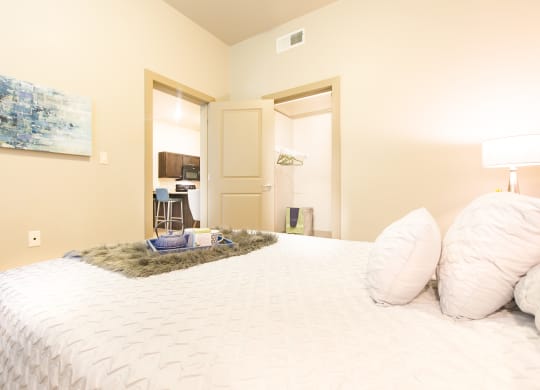 a bedroom with a large bed and a door to a bathroom at Sugar House Apartments By Urbana, Salt Lake City, UT, 84105