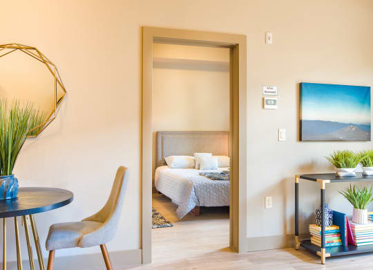 a bedroom with a bed and a table and a mirror at Sugar House Apartments By Urbana, Salt Lake City, UT, 84105
