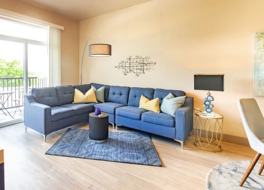 a living room with a blue couch and a rug at Sugar House Apartments By Urbana, Salt Lake City, UT, 84105