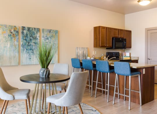 a dining room with a table and chairs and a kitchen at Sugar House Apartments By Urbana, Salt Lake City, UT, 84105