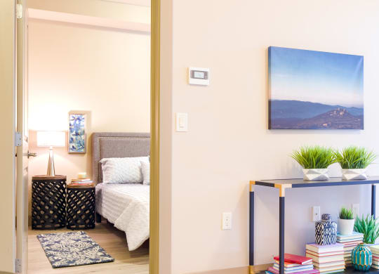 a bedroom with a bed and a table with plants at Sugar House Apartments By Urbana, Salt Lake City, UT, 84105
