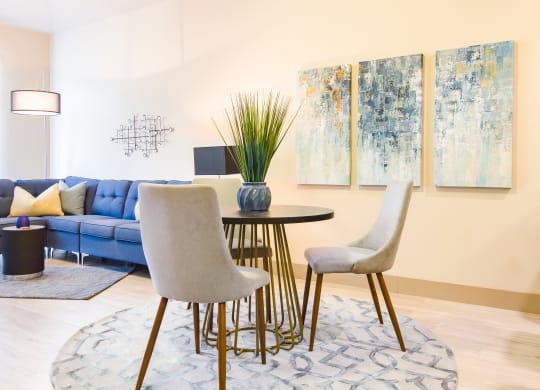a living room with a table and chairs and paintings on the wall at Sugar House Apartments By Urbana, Salt Lake City, UT, 84105