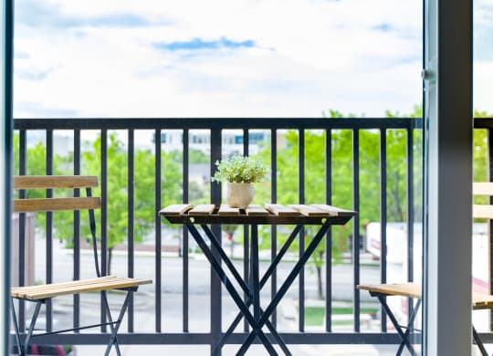 a patio with a table and chairs on a balcony at Sugar House Apartments By Urbana, Salt Lake City, UT, 84105