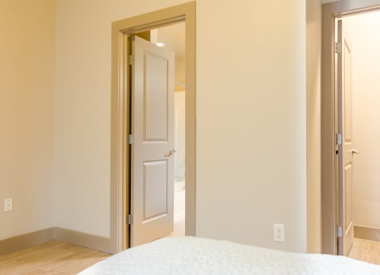 a bedroom with a white door and a white bed at Sugar House Apartments By Urbana, Salt Lake City, UT, 84105