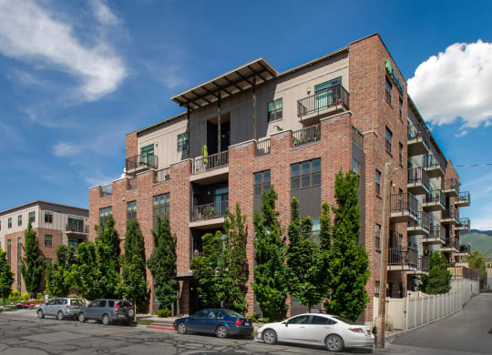 a view of the front of the building with cars parked in front and trees in front of at Sugar House Apartments By Urbana, Salt Lake City, UT, 84105
