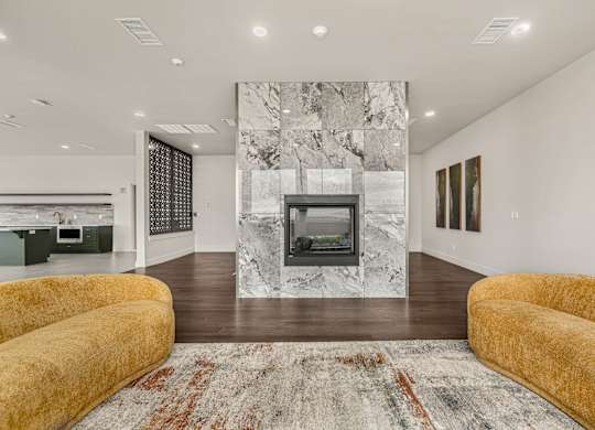 A living room with a fireplace and a rug.