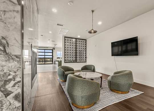 A modern living room with a grey sofa and a TV on the wall.