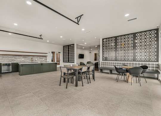A modern kitchen with a dining area and a patterned backsplash.