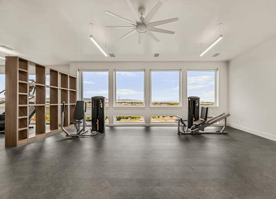 A spacious room with a ceiling fan and two treadmills.
