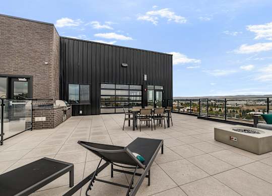 A patio area with a table and chairs overlooking a cityscape.