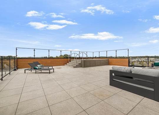 A rooftop patio with a table and chairs.