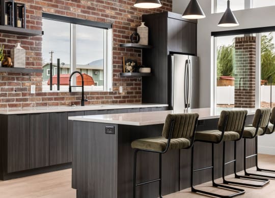 a kitchen with a brick wall and a large island with bar stools