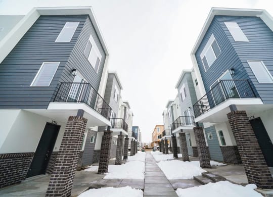 an image of an apartment complex with snow on the ground