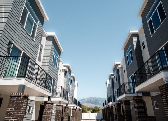 a row of apartment buildings with mountains in the background