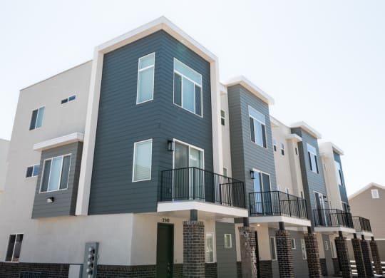 a row of apartment buildings with blue and white siding