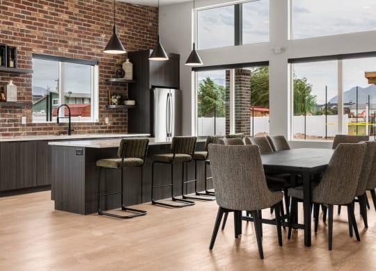 a kitchen with a large table and chairs in front of a brick wall