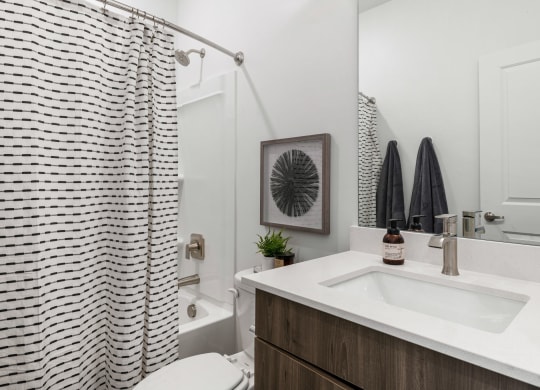 a bathroom with white walls and a black and white shower curtain