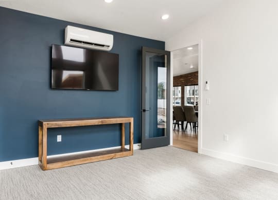 a living room with a tv and a door to a dining room