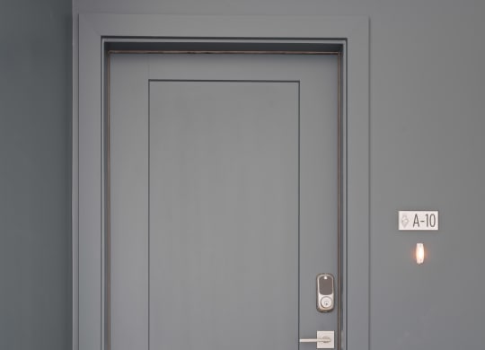 a gray door with a white door frame and a wooden floor
