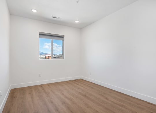 an empty room with white walls and a window