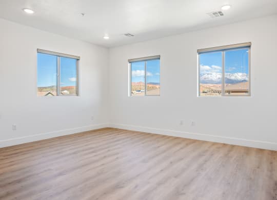 an empty living room with wood floors and white walls
