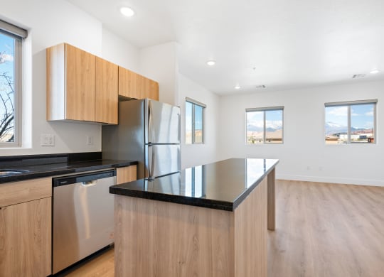 a kitchen with a large island and a stainless steel refrigerator