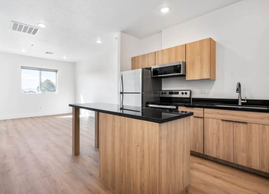 a kitchen with a black counter top and wooden cabinets