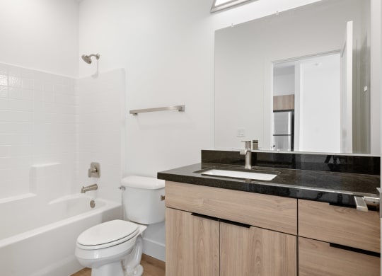 a bathroom with a toilet sink and tub and a mirror