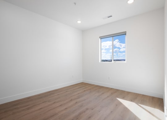 an empty room with white walls and a window