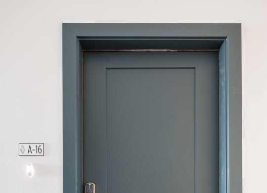 a black door with a white wall and a blue doorframe