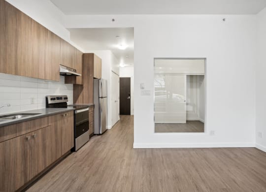 a kitchen and living room with wood flooring and white walls