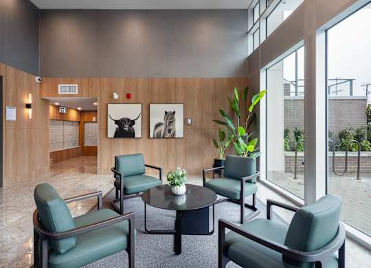 A modern waiting room with green chairs and a glass table.