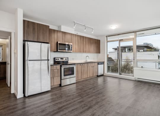 a kitchen with wooden floors and white appliances and a window