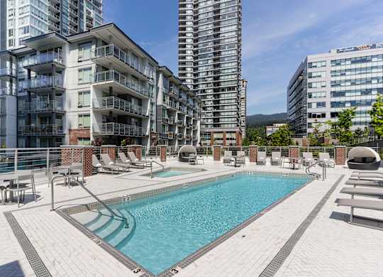 A large swimming pool in front of apartment buildings.