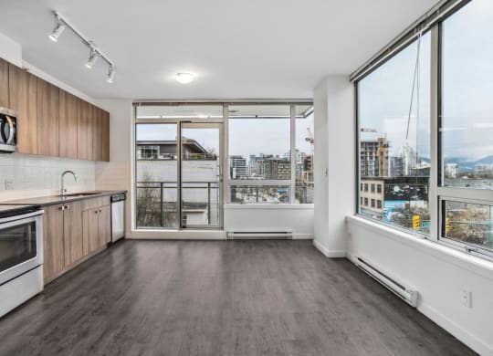 an empty kitchen with a large window and a city view
