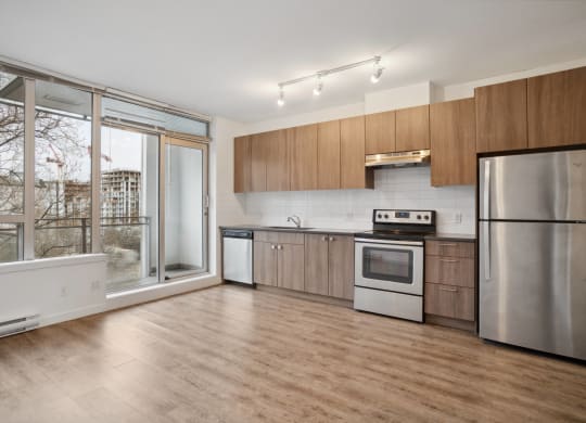 a kitchen with wooden cabinets and stainless steel appliances and a large window