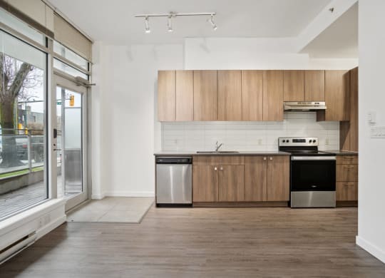 a kitchen with wooden cabinets and stainless steel appliances and a window