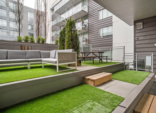 a patio with a couch and a table in front of a building
