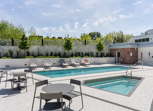 A pool with a table and chairs around it.