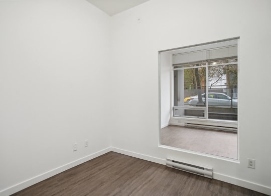 a living room with a large window and wood flooring